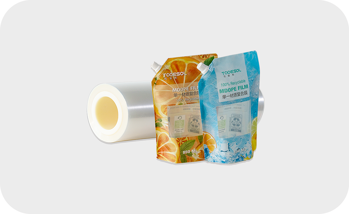 Transparent film roll and two orange and blue Spout Pouches are made of MDOPE, highlighting the 100% recyclable packaging