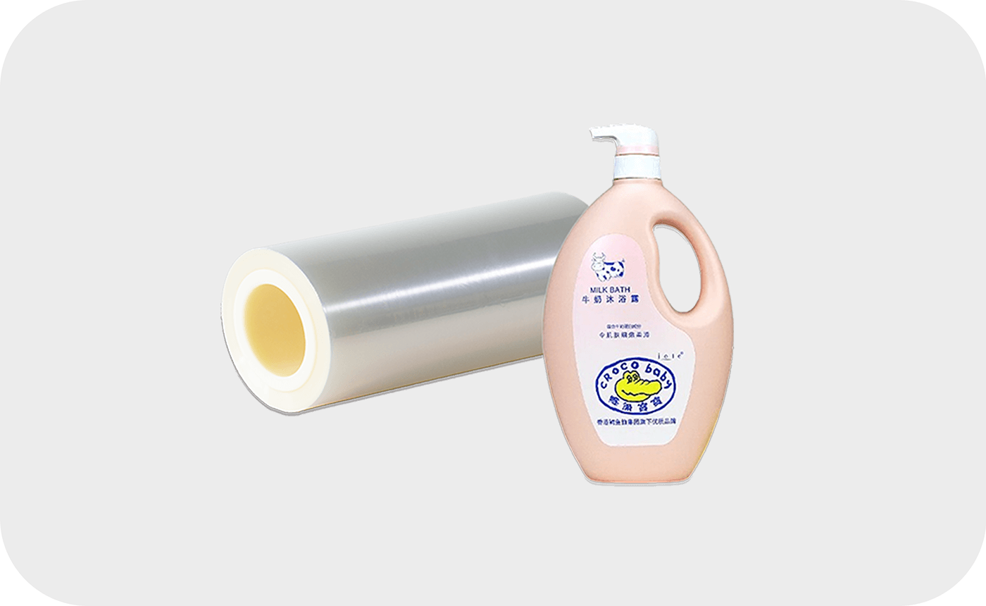 Transparent PE film roll next to a bottle of milk bath liquid.